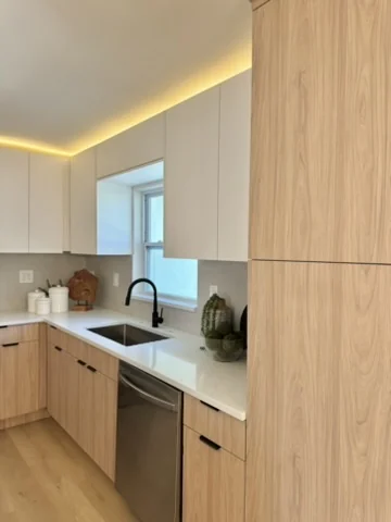 Completed light oak kitchen with integrated storage and black fixtures