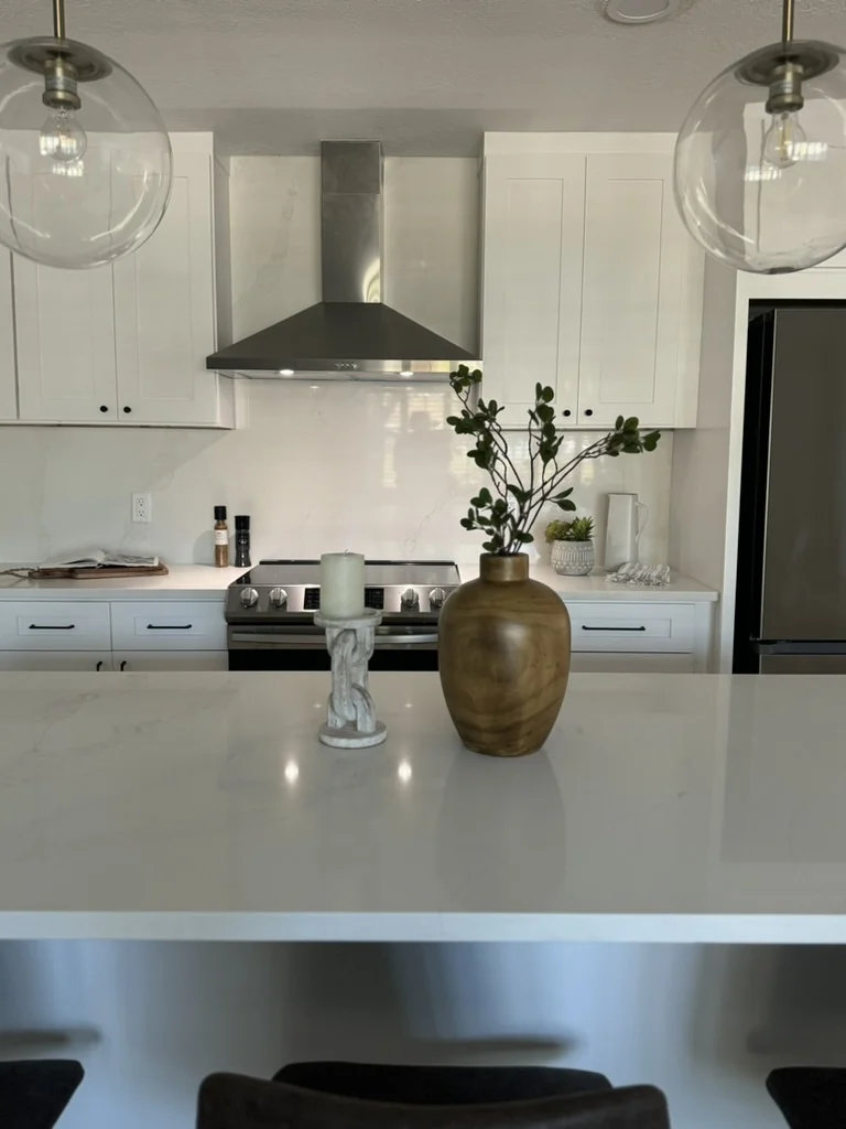 Completed white kitchen with stainless hood and statement globe pendants