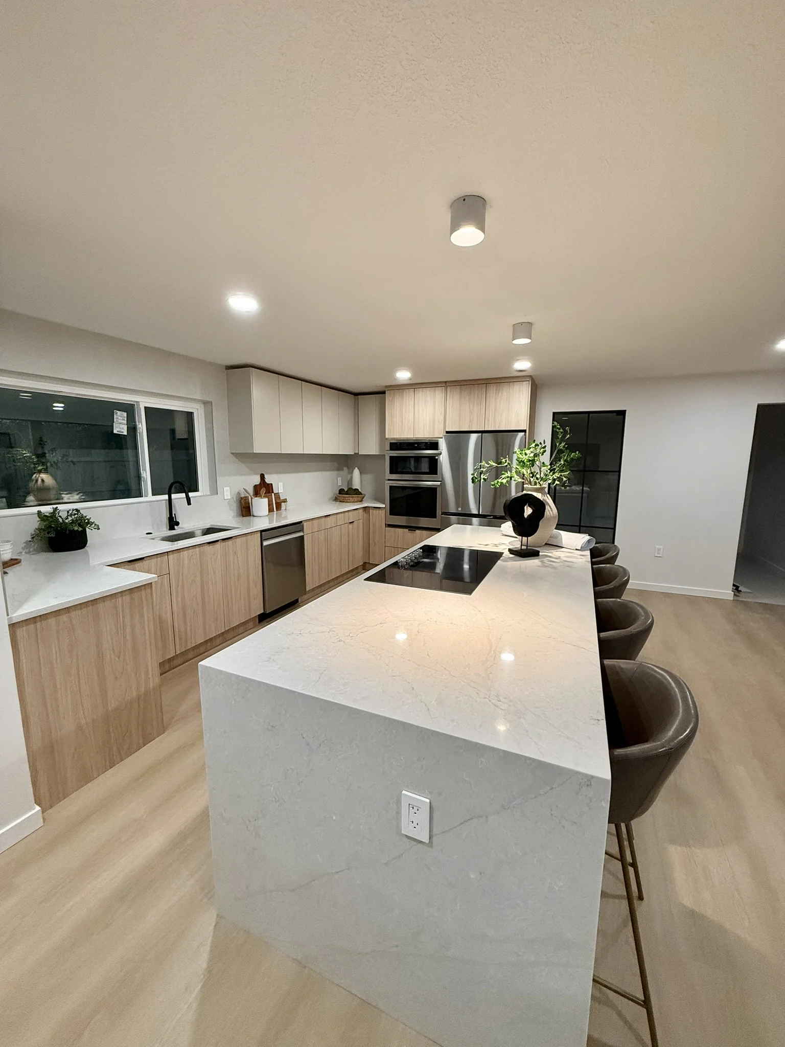 Completed light oak kitchen with waterfall island and integrated appliances